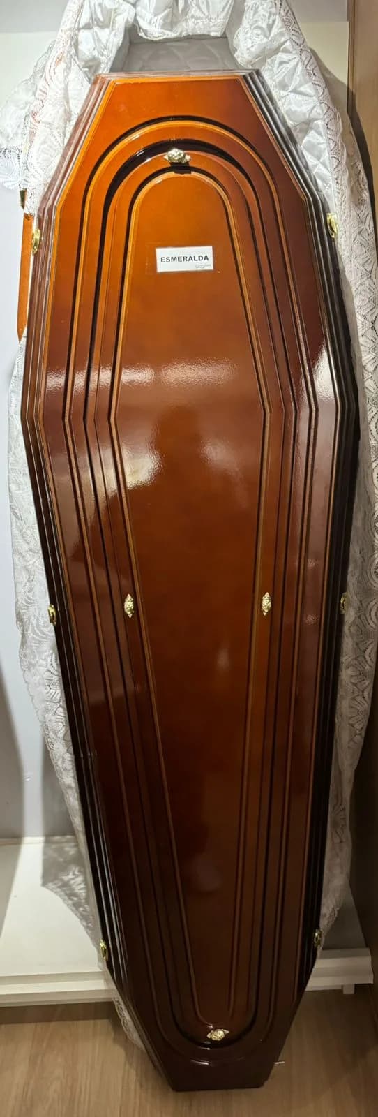 Urna funerária Esmeralda em tom amadeirado brilhante com linhas clássicas.
